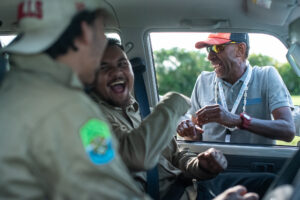 Girringun Rangers sit in a car and share a laugh with a Fijian delegate